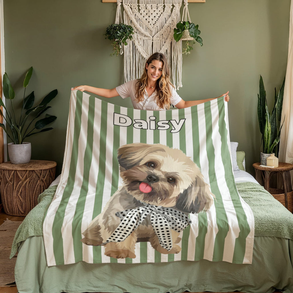 Woman holding a green and white striped blanket with a dog design and 'Daisy' text in a bedroom setting.