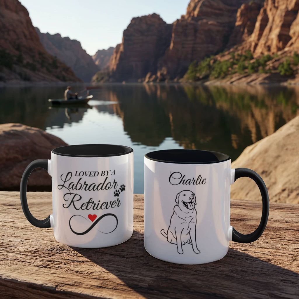 Two mugs with Labrador Retriever designs on a wooden surface with a scenic background.