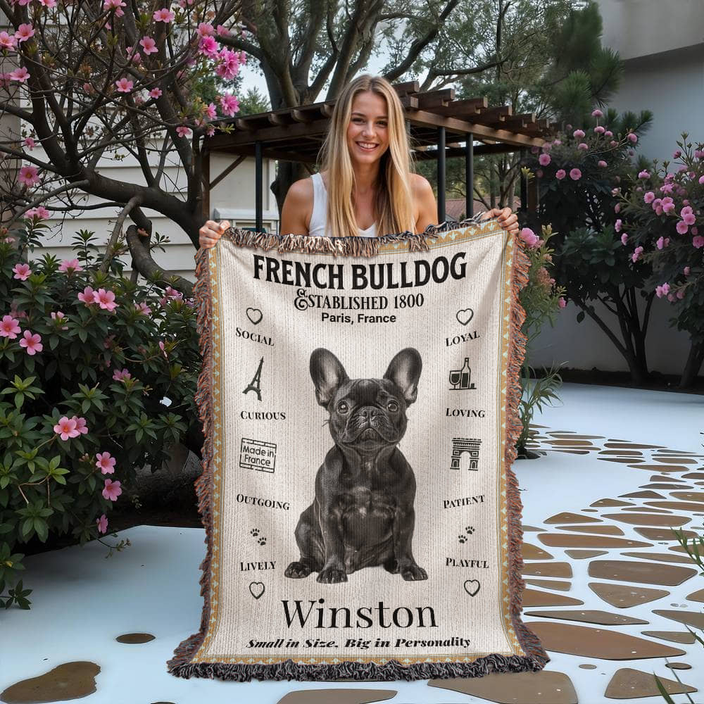 Woman holding a French Bulldog-themed blanket with a dog illustration and text.Personalized with your Frenchie's name and photo.