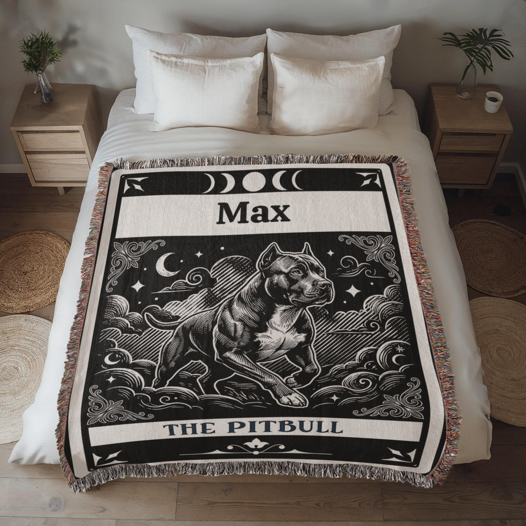 Blanket with a tartot card with a pitbull dog illustration and 'Max' printed on it, draped over a bed.