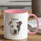 White mug with pink interior and handle featuring a dog's face and name 'Oreo' on a wooden table.