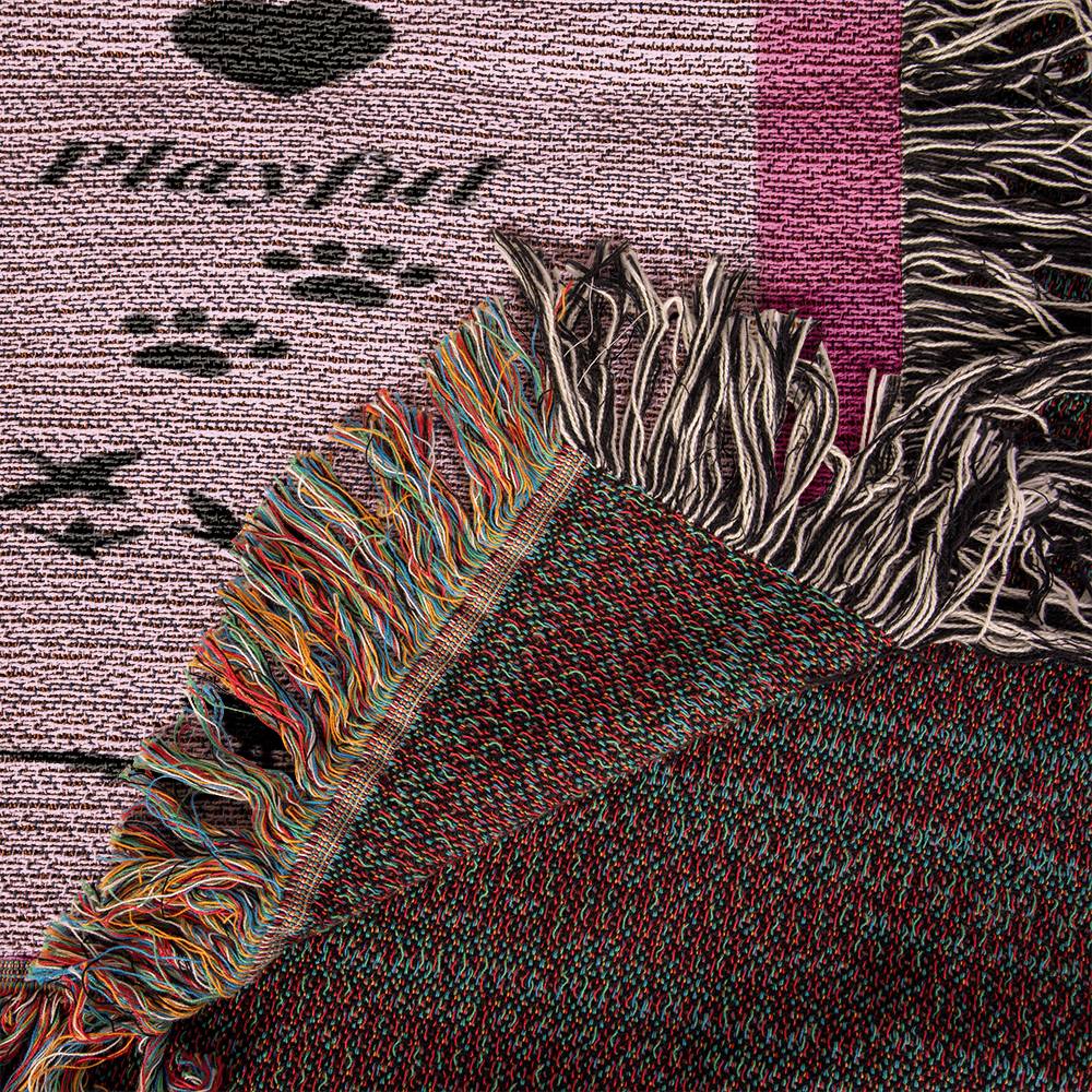 Textured fabric with colorful tassels and paw prints on a patterned background