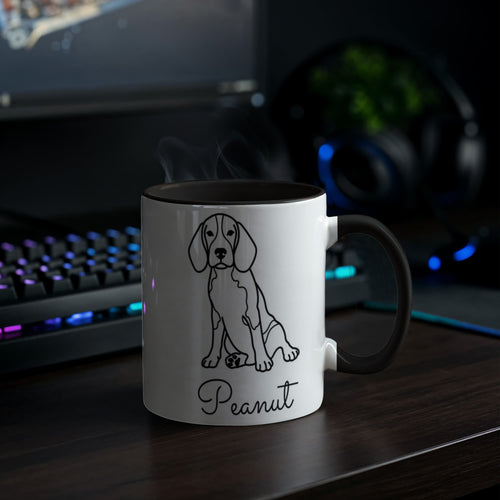 White mug with black rim featuring a dog illustration and 'Peanut' text, placed on a desk with a computer setup in the background.