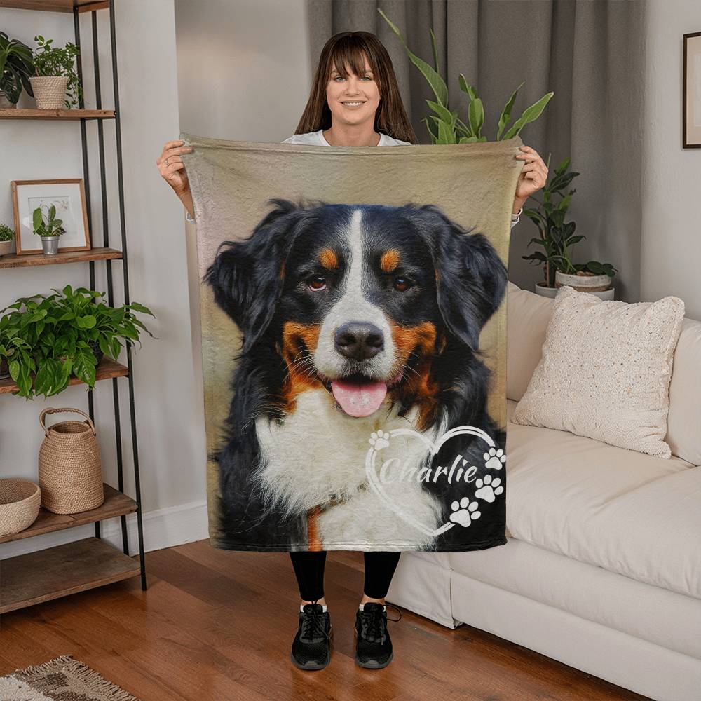 Woman holding a blanket with a dog's face on it in a living room.