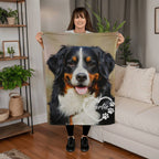 Woman holding a blanket with a dog's face on it in a living room.