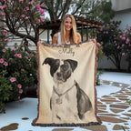 Woman holding a blanket with a dog portrait and 'Molly' written on it, outdoors.