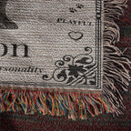 Close-up of a textured fabric with fringes and printed text