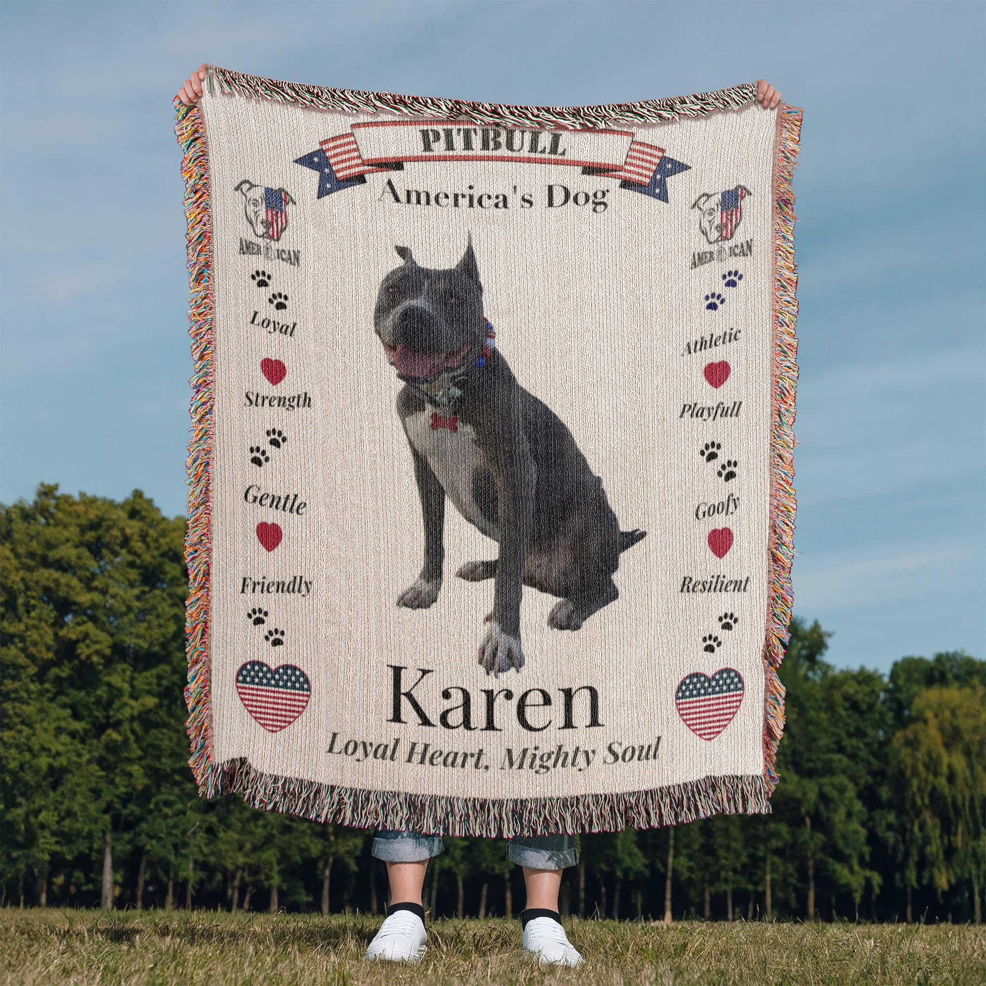 Blanket with a pitbull design and text about the breed, held by a person in an outdoor setting. Personalize your woven blanket with your favorite picture of your Pittie with their name.