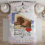 Dog lying on a blanket with a heart and text on a wooden dock by a lake.