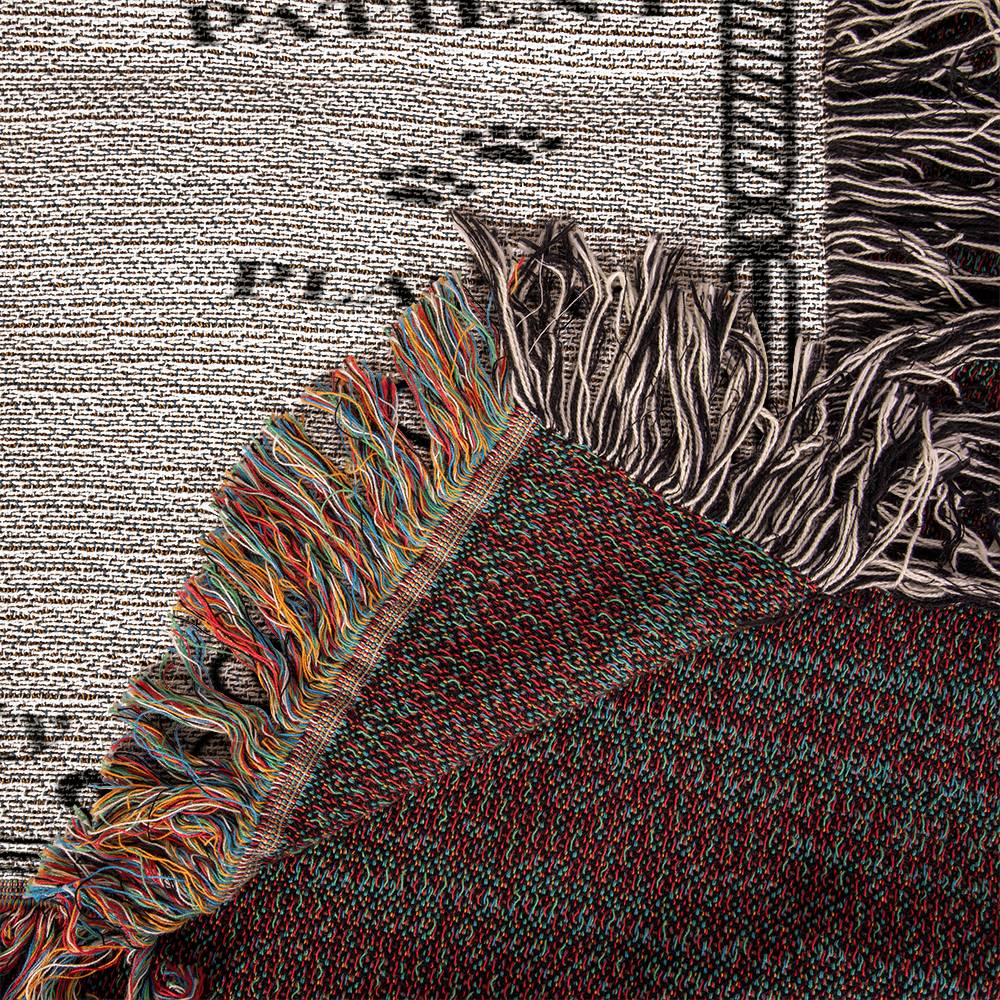 Close-up of a textured fabric with colorful fringe against a newspaper background