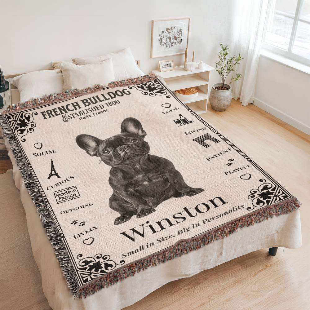Woven Blanket with a French Bulldog design and text on a bed in a room.Personalized with the name and photo of your Frenchie.