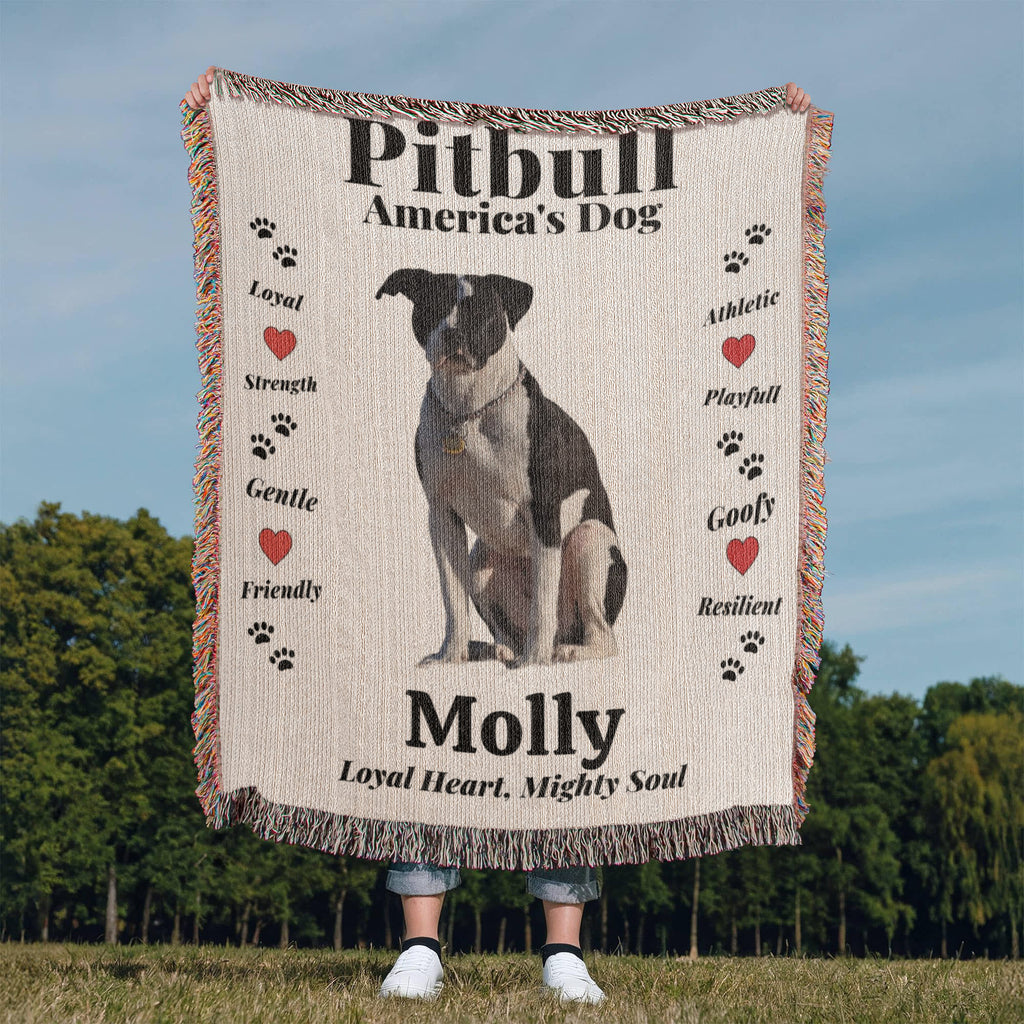 Woven Blanket with a Pitbull illustration and text about the breed, held by a person outdoors.