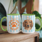 Two mugs with dog-themed designs on a wooden surface.