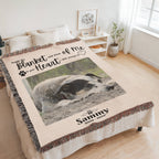 Personalized blanket with a dog photo and text on a bed in a room.