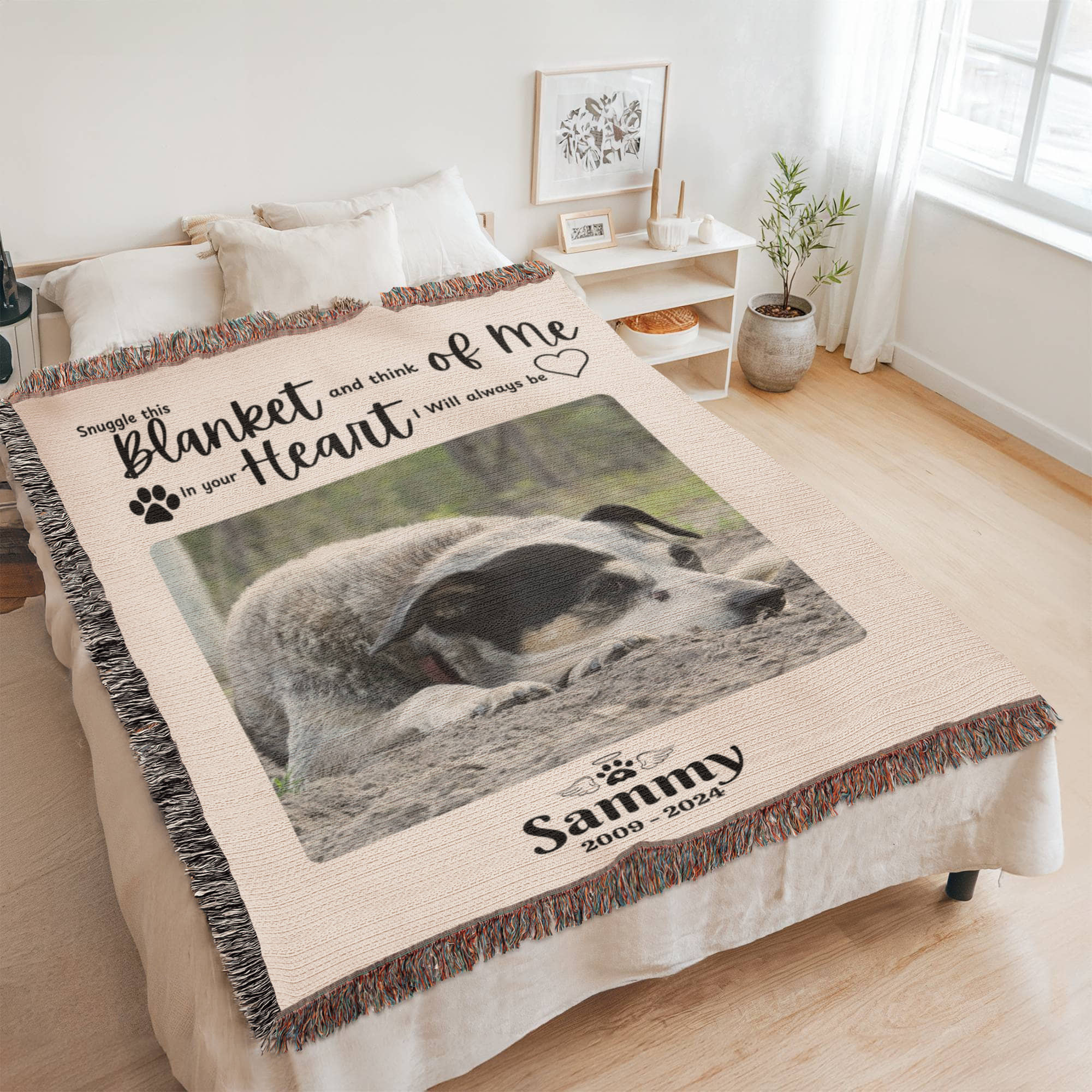 Personalized blanket with a dog photo and text on a bed in a room.