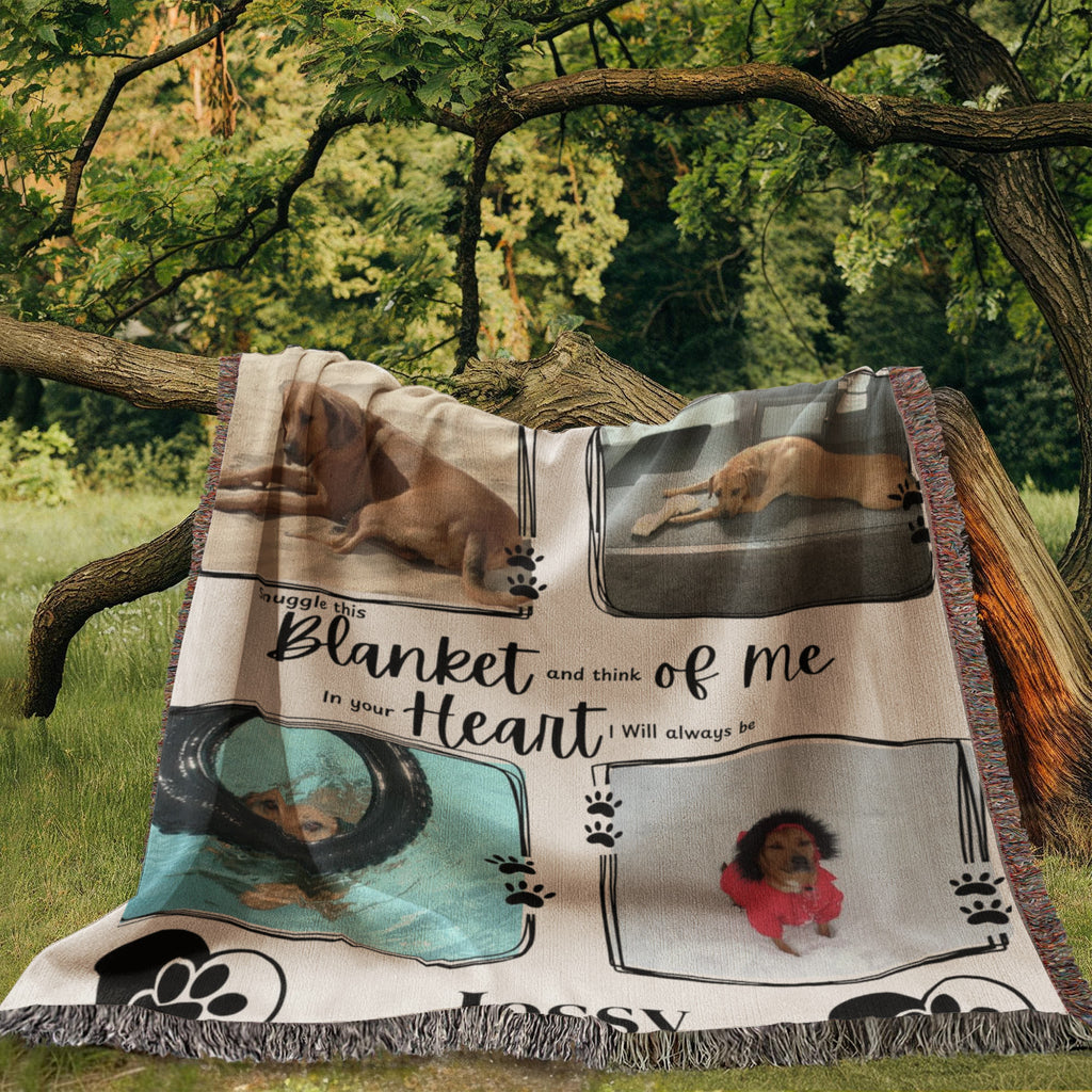 Blanket with dog-themed images and text, placed outdoors on a tree branch.