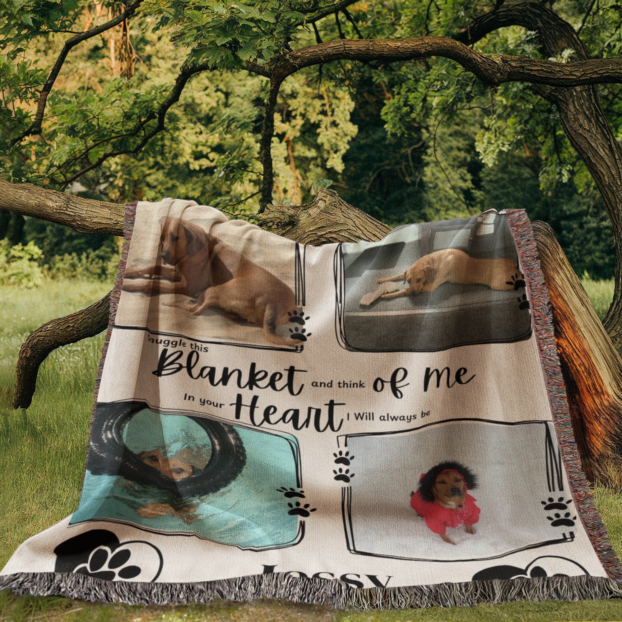 Blanket with dog-themed images and text, placed outdoors on a tree branch.
