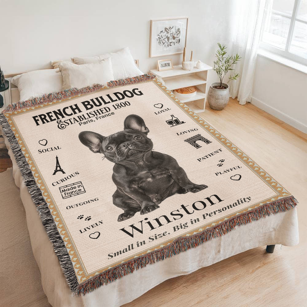 Blanket with a French Bulldog design and text on a bed in a room. Personalized with your Frenchie's name and photo.
