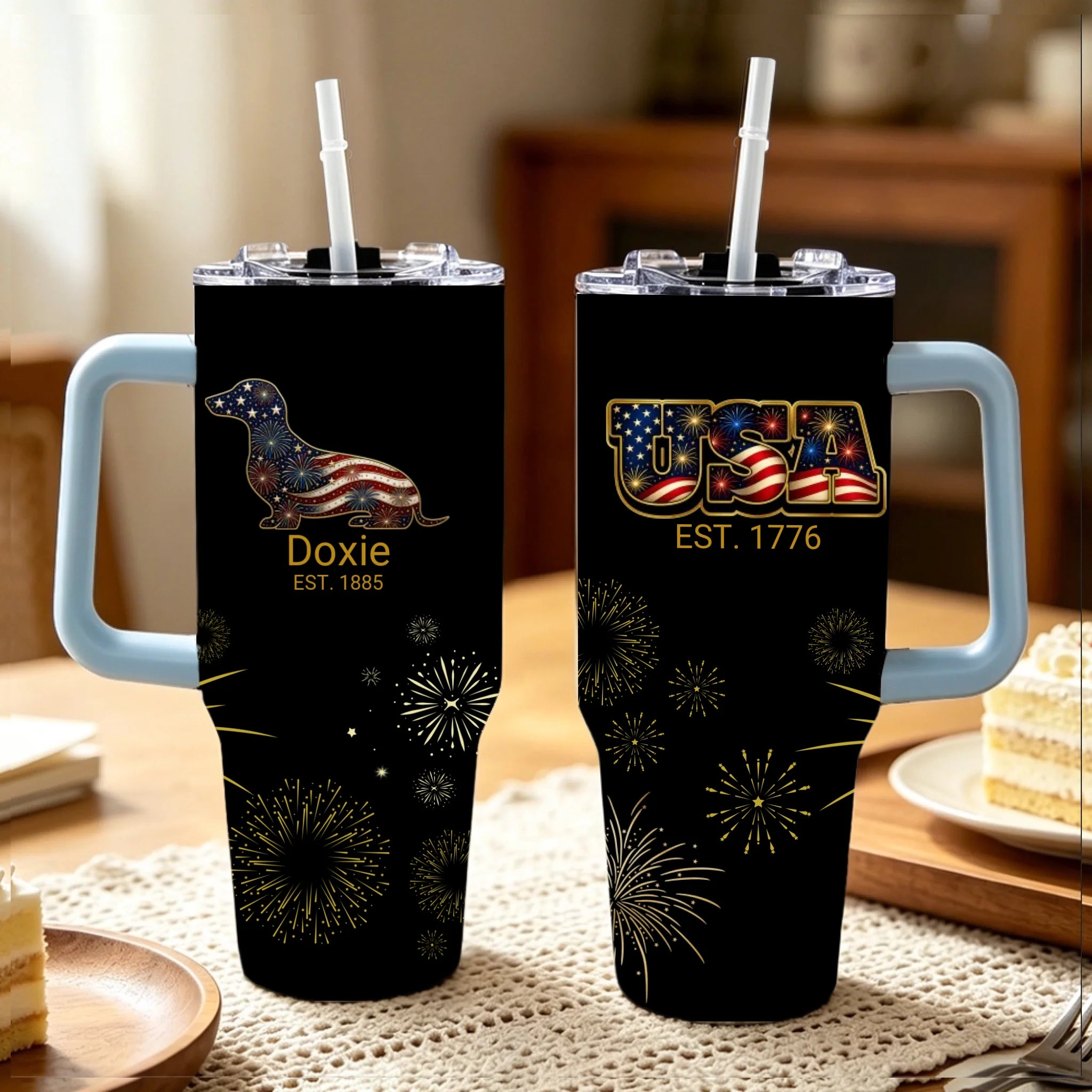 Two black tumblers with handles on a table, featuring patriotic designs.