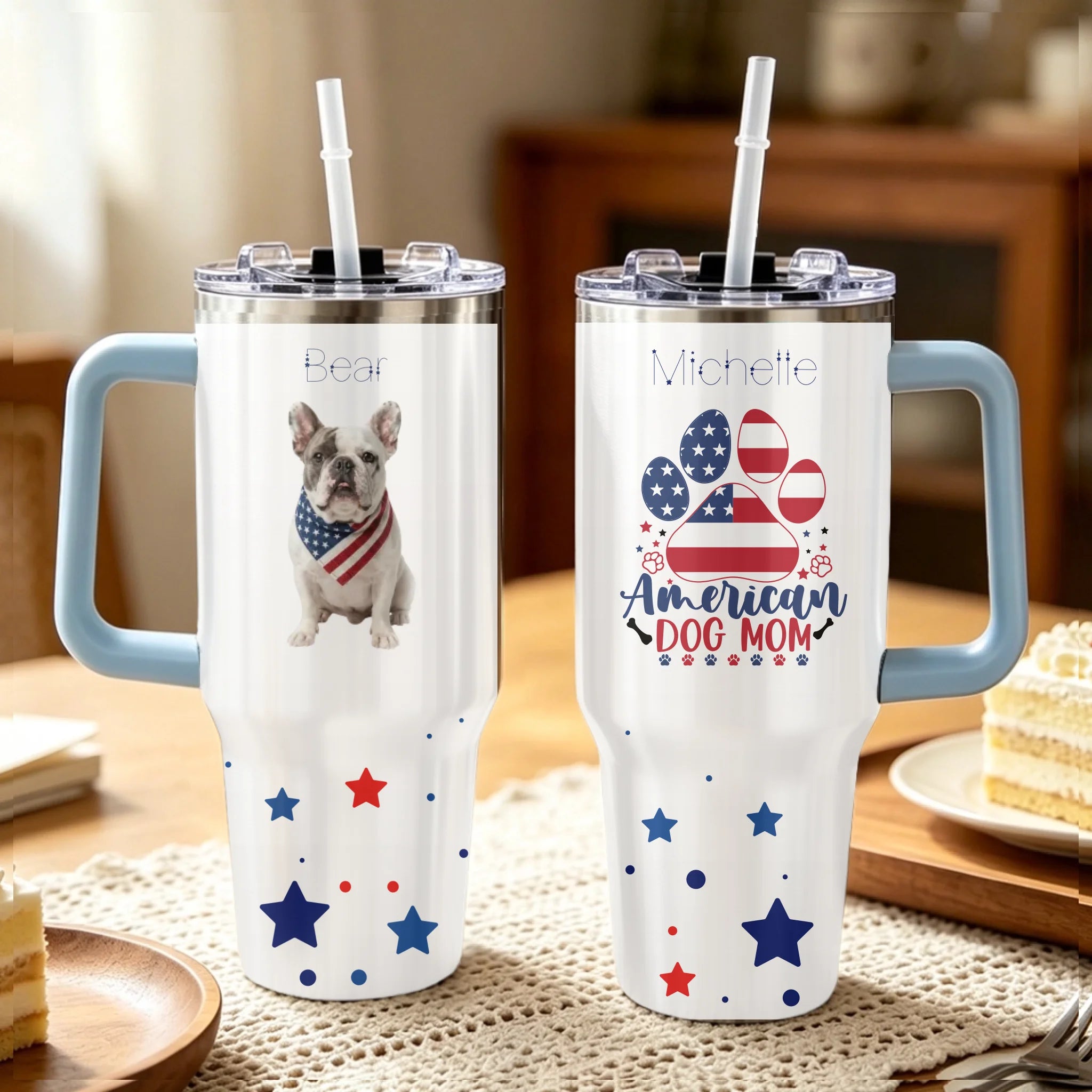 Two tumblers with handles on a table, one featuring a dog and the other with 'American Dog Mom' text.
