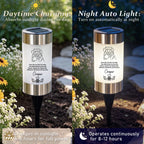 A split-screen comparison showing a solar-powered garden light in daylight on the left and at night on the right. The cylindrical lamp has a white body with black text and illustration, a dark blue solar panel on top, and a black stake.