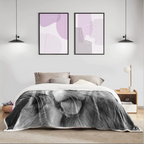 A modern bedroom scene with a bed covered by a large black-and-white personalized photo of a dog-face throw blanket.  