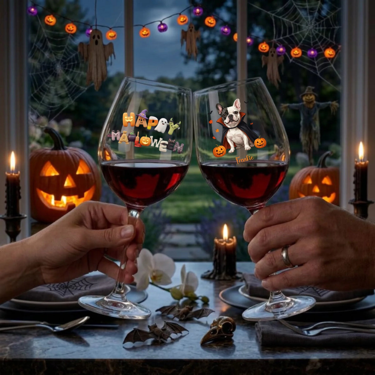 Two hands hold up clear Halloween-themed wine glasses filled with red wine at a dinner table. The glasses feature colorful 'Happy Halloween' text and a cartoon dog with pumpkins.
