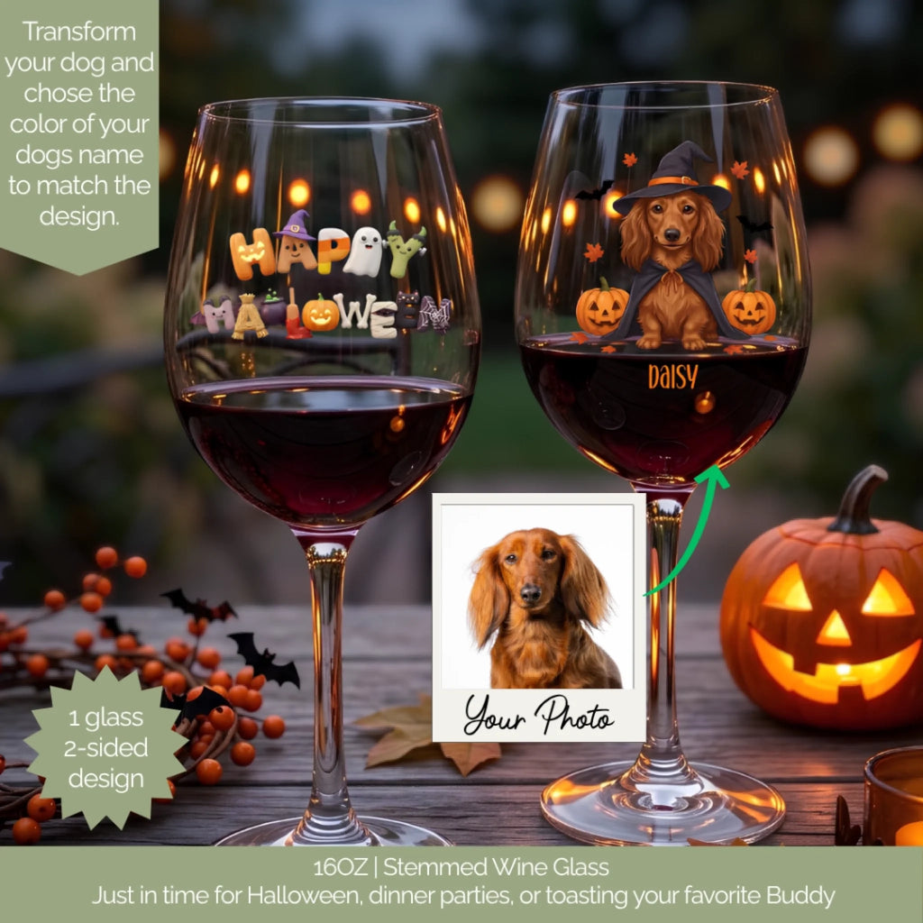 Two personalized stemmed wine glasses filled with red wine, decorated with Halloween graphics including 'Happy Halloween' and a dachshund with pumpkins. The glasses are shown on a wooden table with a carved pumpkin, orange berries, and a small inset photo of a dachshund.