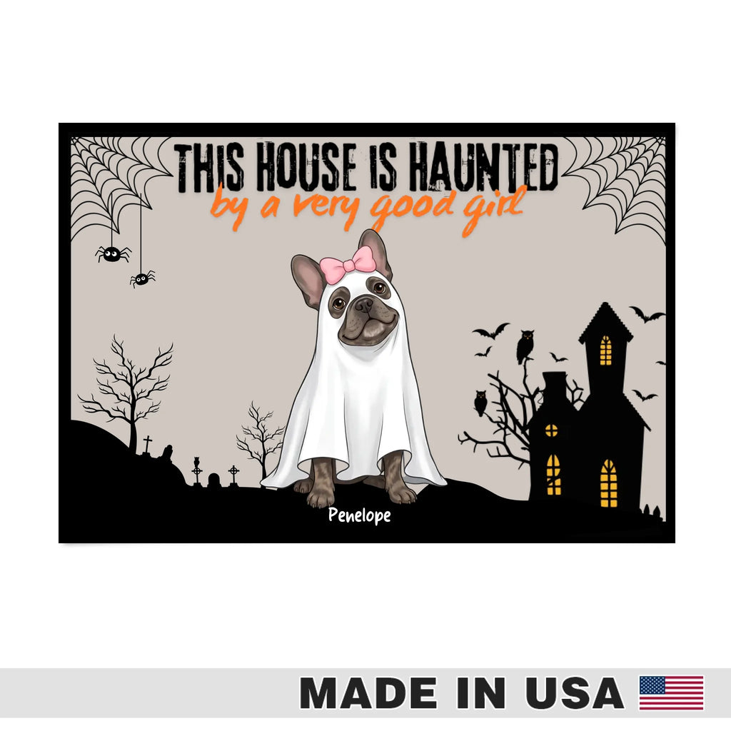 Halloween-themed graphic print featuring a French bulldog dressed as a ghost with a pink bow, standing in front of a haunted house and graveyard. The text reads 'THIS HOUSE IS HUAUNTED by a very good girl' with the name 'Pipette' below.