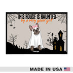 Halloween-themed graphic print featuring a French bulldog dressed as a ghost with a pink bow, standing in front of a haunted house and graveyard. The text reads 'THIS HOUSE IS HUAUNTED by a very good girl' with the name 'Pipette' below.