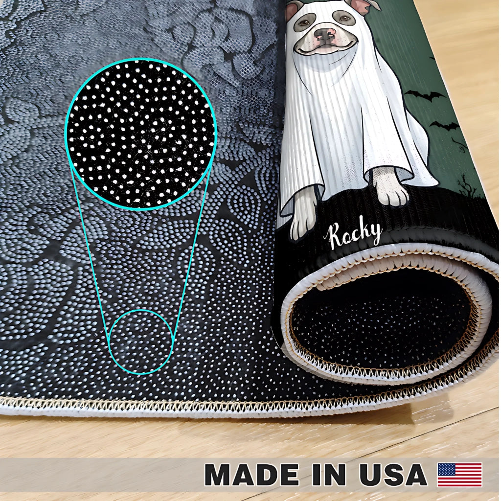 A rolled sheet of black fabric with a white dotted pattern and a printed illustration of a dog in a white ghost costume, shown on a light wood floor. A circular inset highlights the fabric's dotted texture.