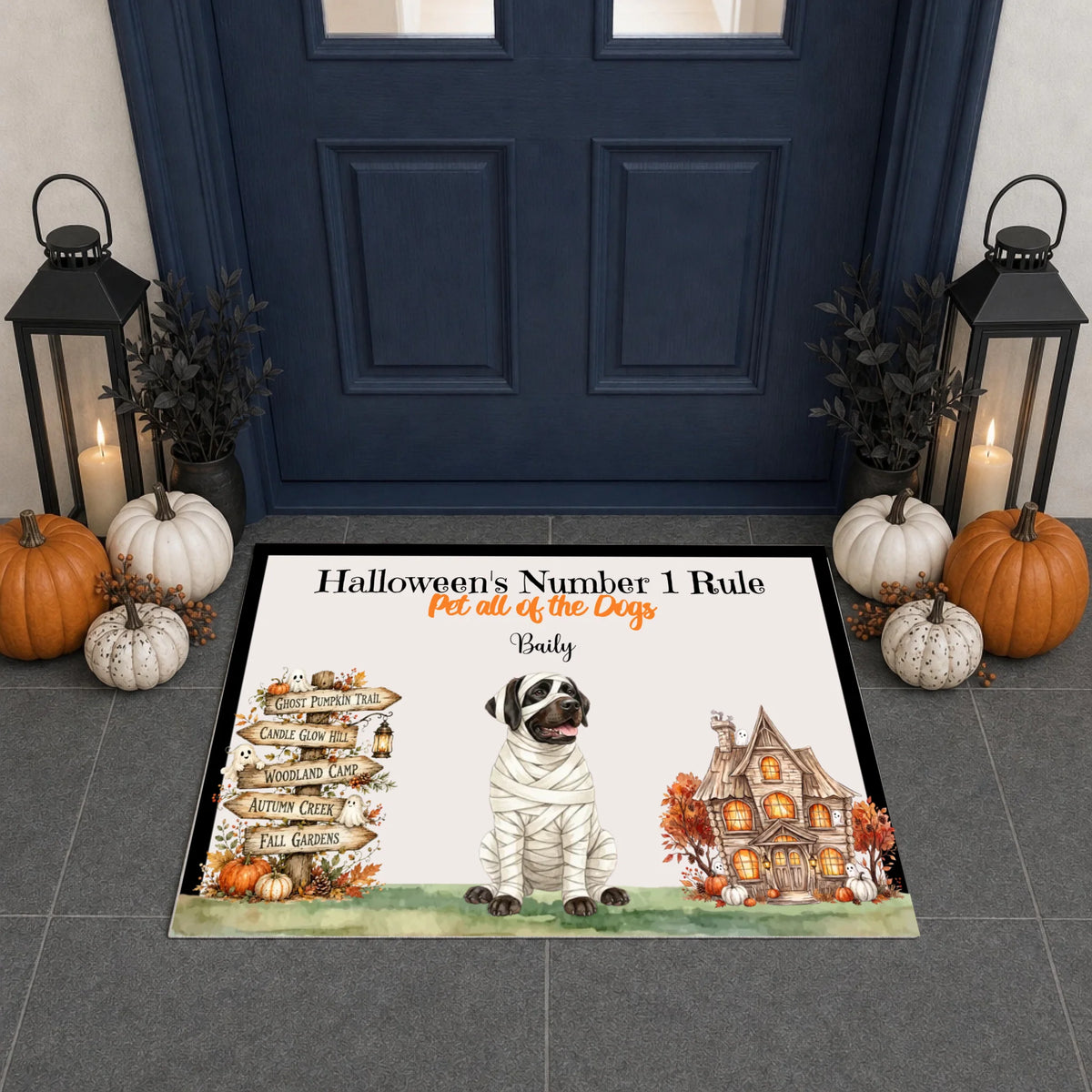 A personalized Halloween doormat displayed in front of a dark blue front door. The mat features a mummy dog, a haunted house, a signpost, and the text 'Halloween's Number 1 Rule For all of the Dogs' followed by the name 'Bebey'.