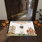 A personalized Halloween-themed doormat displayed on a wooden entryway floor. The mat features a custom design with the text 'Halloween's Number 1 Rule' and 'Pet all of the Dogs - Bailey', accompanied by an illustration of a mummy dog, a haunted house, and a directional signpost.