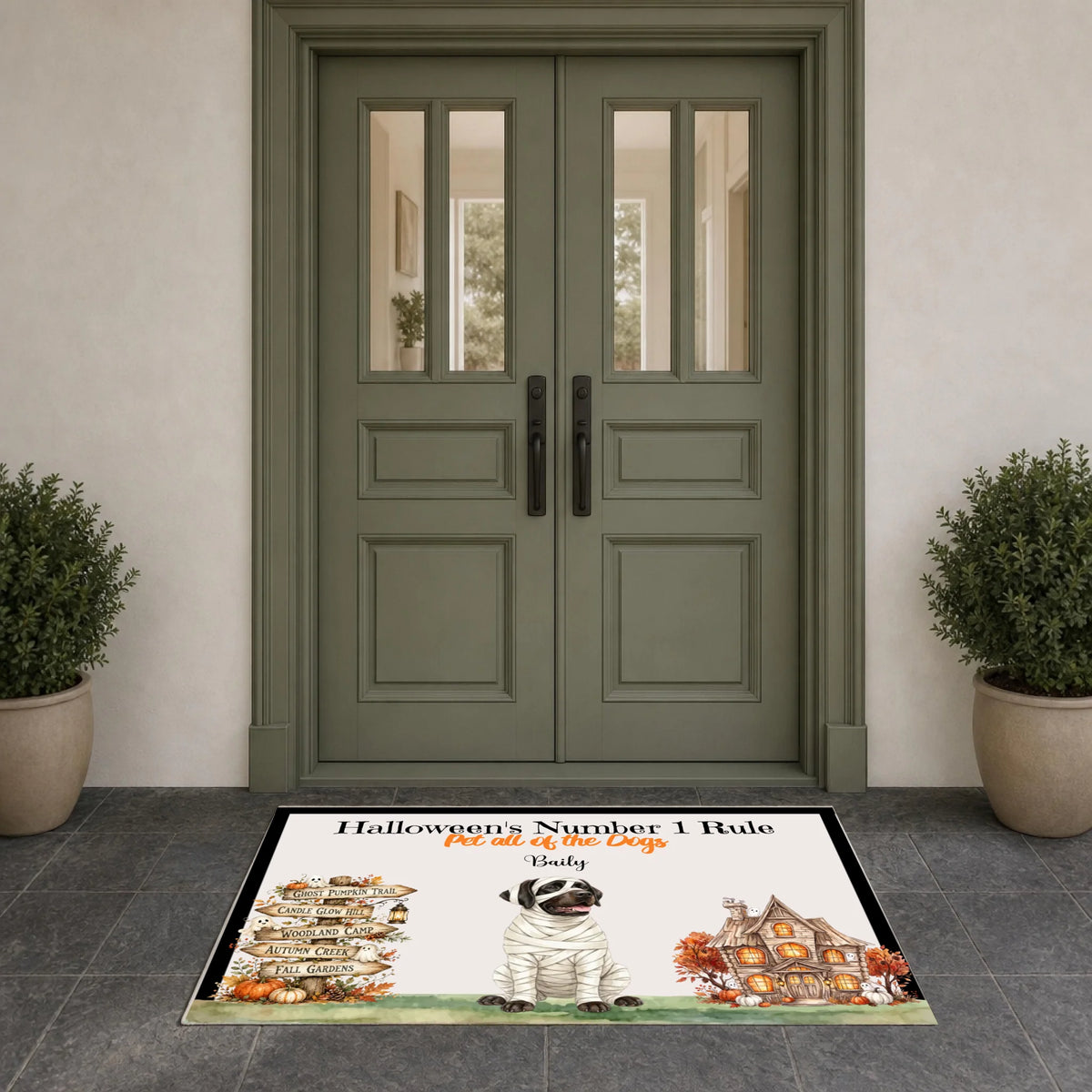 A rectangular Halloween-themed doormat displayed in front of a double door. The mat features the text 'Halloween's Number 1 Rule' and 'No cats of the Dog.