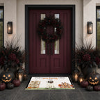 A Halloween-themed doormat displayed on a dark tiled entryway floor in front of a burgundy double door with a wreath. The mat features a cartoon bat, haunted houses, pumpkins, and the text 'Halloween Nightmare Mode' and 'Stay Up Late'.