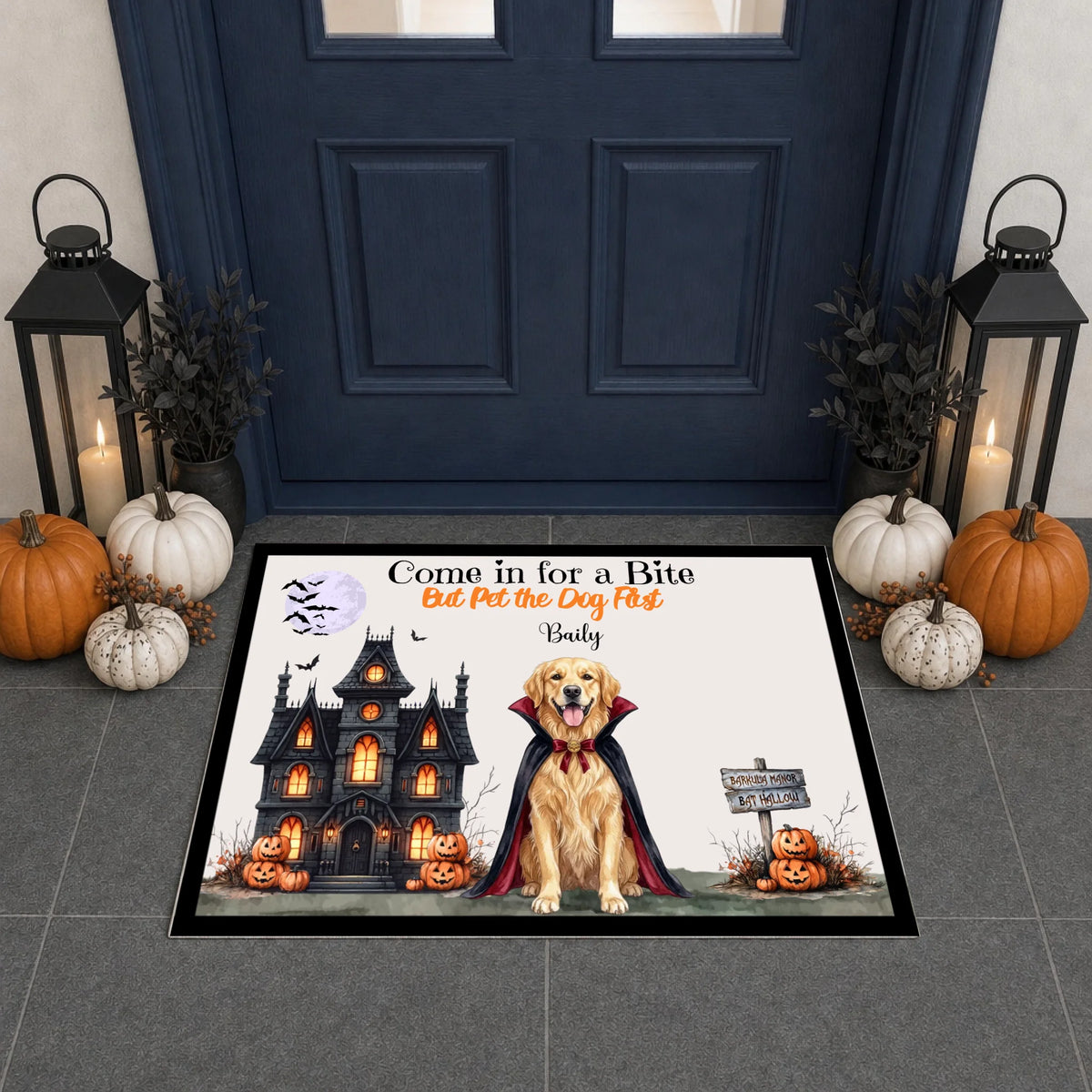 A rectangular Halloween-themed doormat displayed in front of a dark blue front door. The mat features a golden retriever dressed as a vampire in front of a haunted house, with pumpkins, bats, and the text 'Come in for a Bite Eat Pet the Dog First: Baby'.