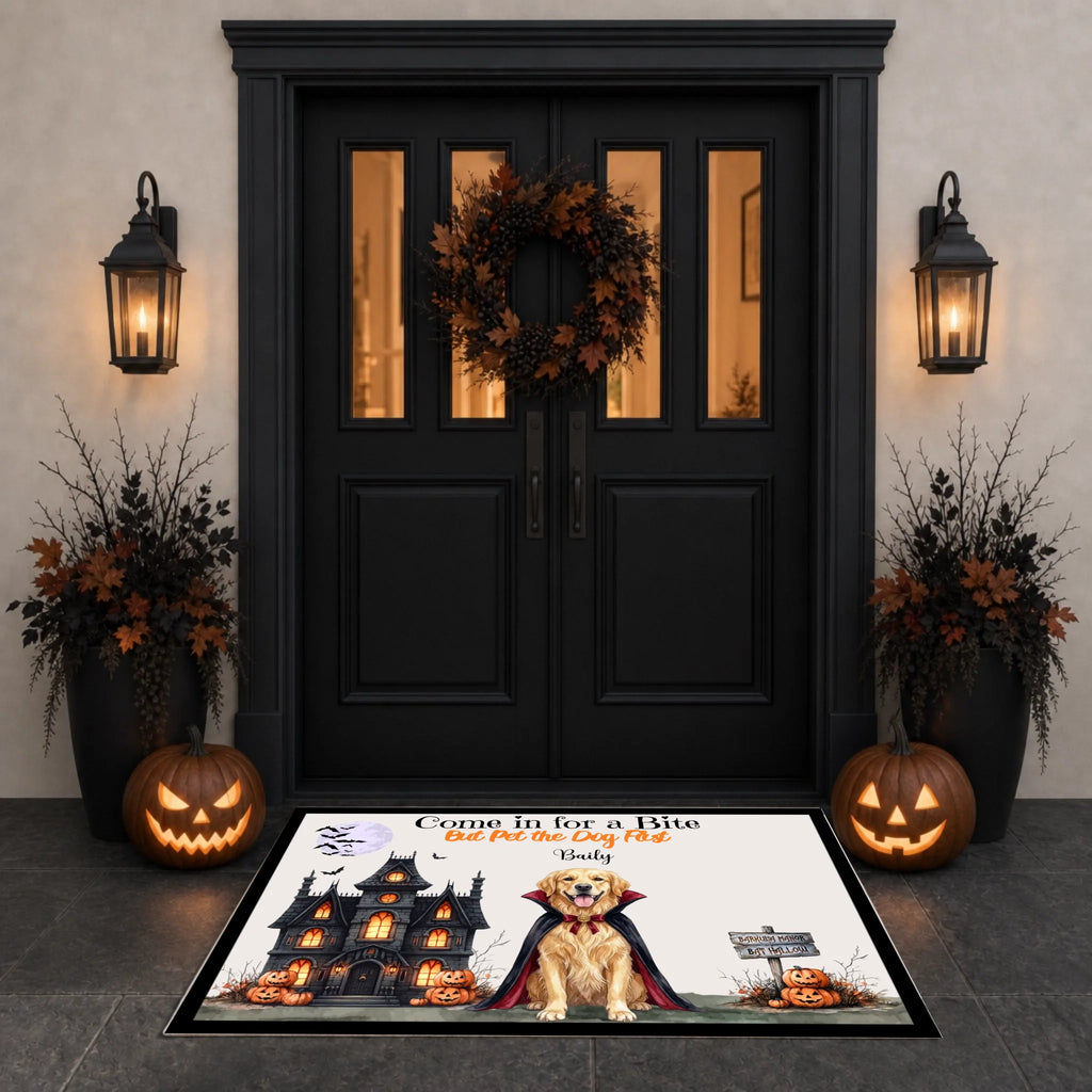 A Halloween-themed doormat displayed in front of a black double door decorated with a wreath, wall lanterns, potted plants, and jack-o'-lanterns. The mat features an illustration of a vampire dog with flames in its eyes, a haunted house, pumpkins, and the text 'Come in for a Bite Before You Die By: Dr.