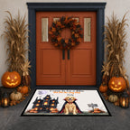 A Halloween-themed rectangular doormat displayed in front of a decorated front door. The mat features a black castle, a vampire in a cape, a golden retriever, and the text 'Come In for a Wife Just for the Fun of You'.