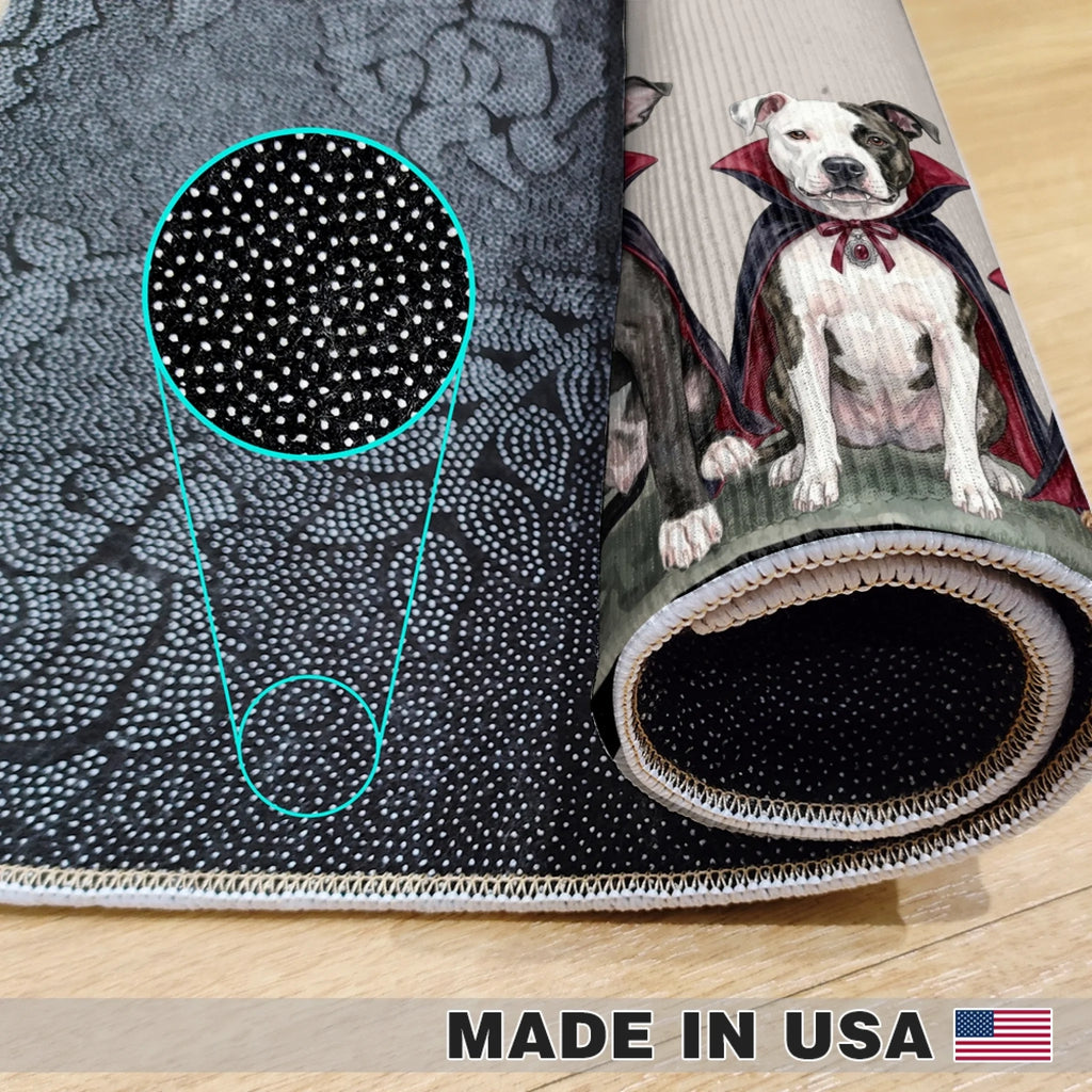 A rolled area rug shown on a light wood floor, featuring a black and gray abstract pattern on one side and a printed illustration of a white pitbull-type dog with a red cape on the other. A circular inset highlights the dense small dot pattern.