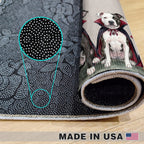 A rolled area rug shown on a light wood floor, featuring a black and gray abstract pattern on one side and a printed illustration of a white pitbull-type dog with a red cape on the other. A circular inset highlights the dense small dot pattern.