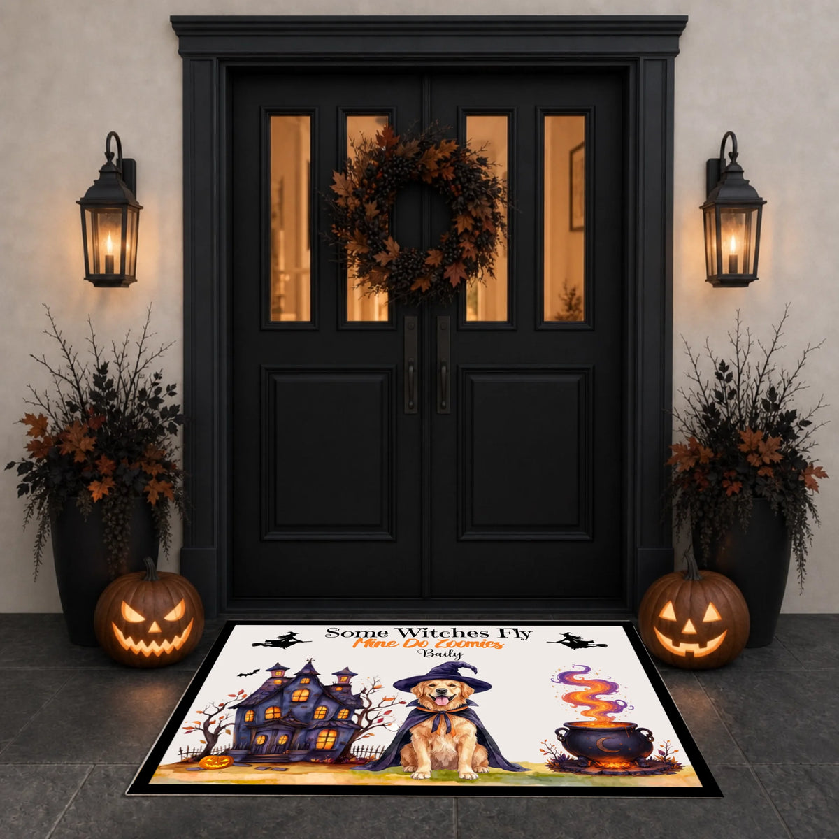 A Halloween-themed doormat displayed in front of a black double door. The mat features a cartoon dog in a witch hat, a haunted house, a cauldron, and the text 'Some Witches I Know'.