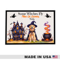 A framed Halloween-themed art print featuring a golden retriever dog in a witch hat beside a haunted house and a bubbling cauldron, with the text 'Some Witches Fly Mine Do Zoumies Badly.' A 'MADE IN USA' banner appears along the bottom of the overall image.