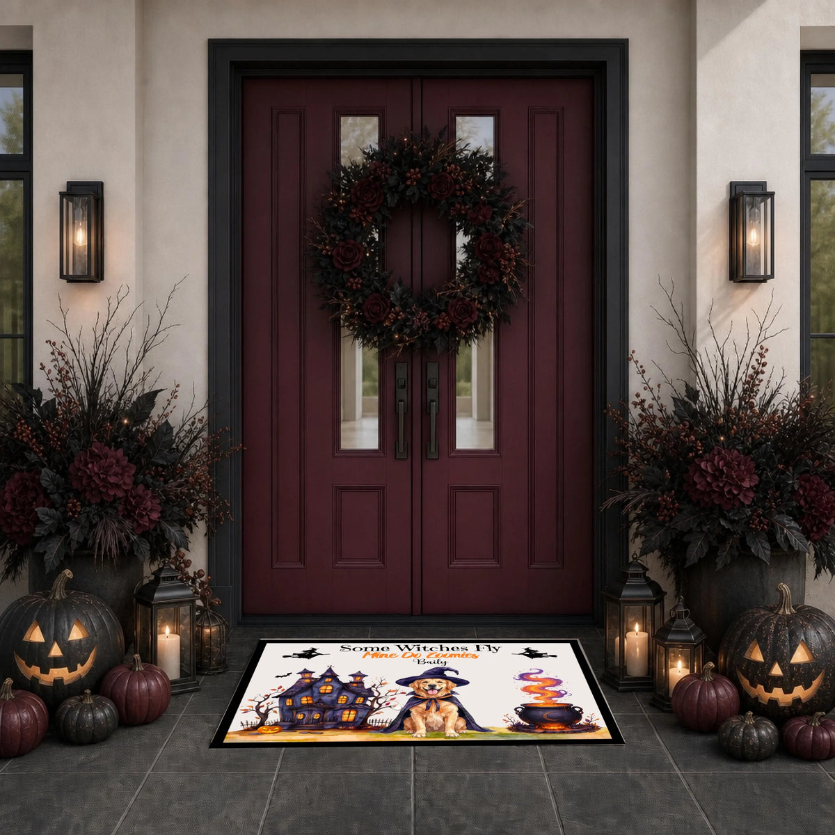 A Halloween-themed doormat featuring a cartoon dog in a witch hat, a haunted house, a cauldron, and the text 'Spooky Witch Hunt' is displayed in front of a dark red double door decorated with a wreath and fall foliage.