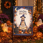 A Halloween-themed garden flag displayed on a black flagpole outdoors in a decorated yard. The flag features an illustration of a golden retriever dressed as a witch with the text 'Witch Better Have Treats' and the name 'Cooper' on a banner.