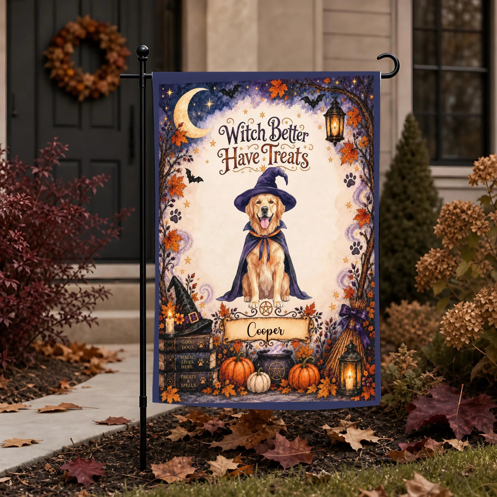 A Halloween garden flag displayed on a black metal stand in a yard. The flag features an illustrated golden retriever wearing a witch hat and cape, surrounded by pumpkins, autumn leaves, a witch hat, a broom, and the text 'Witch Better Have Treats' with a personalized nameplate reading 'Cooper'.