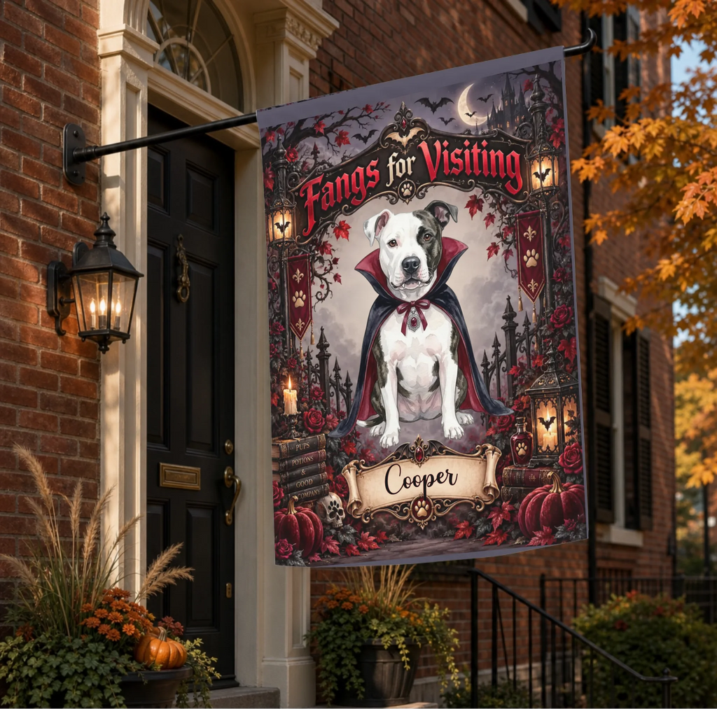 A decorative Halloween flag hanging from a black metal house bracket on a brick home exterior. The flag features a pitbull-type dog dressed as a vampire with the text 'Fangs for Visiting' and the name 'Cooper' at the bottom.