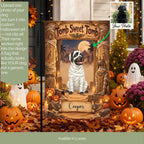 A Halloween-themed garden flag displayed on a black flagpole in a decorated yard. The flag features a mummy dog sitting in front of an Egyptian tomb design with the text 'Tomb Sweet Tomb' and the name 'Cooper' at the bottom.
