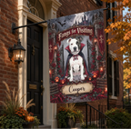 A decorative Halloween house flag hanging from a black metal bracket on a brick house porch. The flag features a white pitbull-type dog dressed as a vampire with the text 'Fangs for Visiting' and a custom name plaque reading 'Cooper.