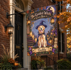 A decorative Halloween house flag hanging from a black metal bracket outside a brick home. The flag features an illustrated golden retriever dressed as a witch with the text 'The Goodest Witch Lives Here' and the name 'Buddy' on a purple banner.