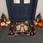 A Halloween-themed rectangular doormat displayed in front of a dark blue front door. The mat features a golden retriever dressed as a vampire with the text 'Fangs for Visiting' and the name 'Bally' at the bottom.